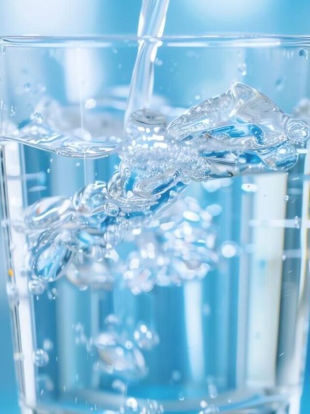 Copo transparente sendo preenchido com água limpa e cristalina.